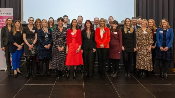 A group of people from all the organisations involved in the UK MND Research Institute, standing together, smiling for a photograph.